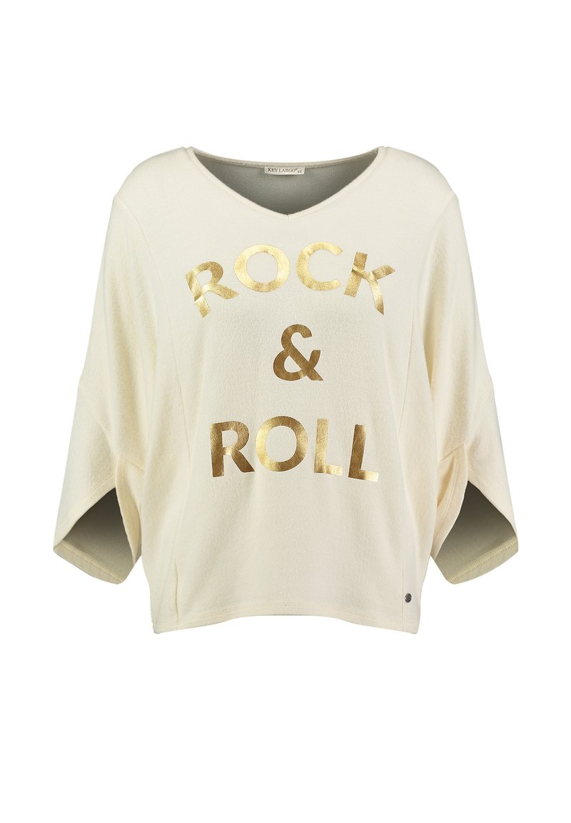 Camiseta de estilo oversized en color crema claro con cuello en V, que presenta texto en dorado "ROCK & ROLL" en la parte frontal y mangas cortas. Textura suave.