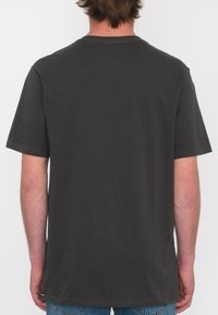 Camiseta de manga corta de color gris oscuro, hecha de algodón, con cuello redondo estándar y un corte relajado, sin patrones ni gráficos visibles.