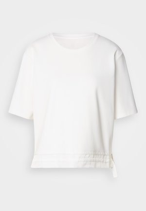 T-shirt blanc à manches courtes en tissu doux. Présente un col rond et un ourlet incurvé avec un détail de lien sur le côté en bas.