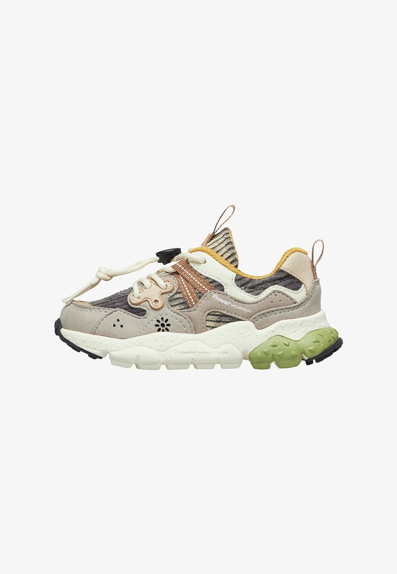 Zapatilla gris y beige con materiales de textil y ante. Presenta una parte superior estampada, suela de goma con acentos verdes y un sistema de cordones.