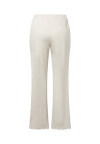 Crème-kleurige, geribde gebreide broek met een elastische tailleband en uitlopende benen, met een zachte textuur en lichtgewicht materiaal.