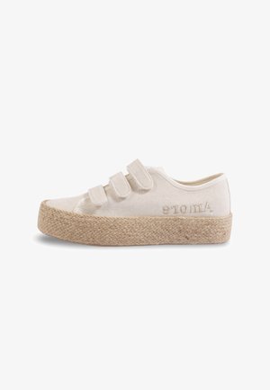 Baskets basses en toile beige avec trois bandes Velcro et semelle en jute tressée, détail brodé sur le côté, présentées de profil sur fond blanc.