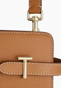 Bolso de mano de cuero color tostado con acabado texturizado, herrajes dorados y un acento en forma de T. Detalles de costura en los bordes y correa ajustable.