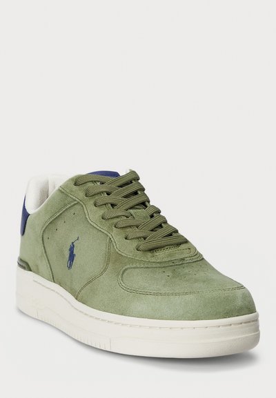 Olive rohelise sametise pealsega sneaker valge tallaga, millel on rohelised paelad, sinine konts ja küljes väike logo. Tekstureeritud pind.