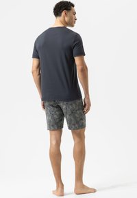 Navy crew-neck t-shirt paired with patterned, mid-thigh shorts in blue and cream paisley design, lightweight cotton fabric, casual fit.