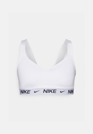 Valkoinen urheil bras, jossa on V-kaula-aukko ja leveät hihnat. Musta Nike-logo näkyy joustoresorissa tuen tarjoamiseksi. Sileä kankaan rakenne.