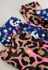 Leggings colorés pour enfants présentant deux motifs : l'un avec un fond bleu marine de licornes et d'étoiles, et l'autre avec un imprimé rose et léopard.