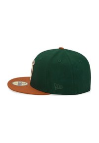 Green cap with a brown visor, featuring textured fabric, logo embroidery on the side, and a rounded crown design.