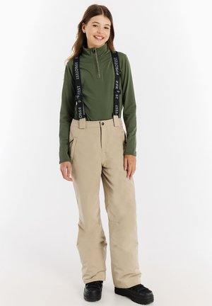 Beige skibroek met verstelbare zwarte bretels, gecombineerd met een groene longsleeve top met een half-rits kraag en een gladde textuur.