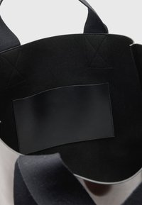 Borsa a spalla nera in tessuto con manici intrecciati resistenti e una morbida tasca in pelle all'interno. Texture morbida e forma rotonda con un ampio interno.