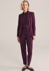 Elegant burgundské kalhoty s blejzrem se zásluhou, ladící košile a zúženými kalhotami. Hladká textura a minimální detaily.