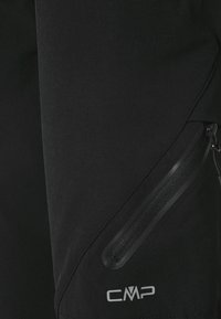 Musta takki, jossa on sileä pinta, vetoketjullinen tasku ja hopeanvärinen CMP-logo alhaalla oikeassa kulmassa.