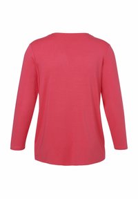 Langarmshirt in koraalroze, gemaakt van zachte stof. Heeft een ronde hals en een eenvoudig ontwerp zonder zichtbare patronen of accenten.