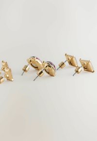 Gold-tone earrings with various shapes, featuring purple and clear stones, polished metal finishes, and brass hardware accents.
