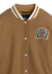 Brun uldblanding varsityjakke med ribbet krave i hvidstriber, sølvfarvede trykknapper, og et cirkulært broderet logo med laurbærdetaljer.