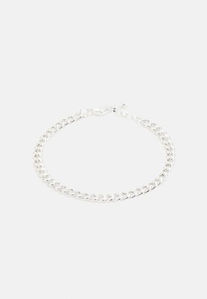 Bracelet chaîne en argent avec des maillons ovales et un fermoir mousqueton sur un fond uni clair.