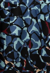 Motif floral abstrait avec des formes superposées bleu marine, noir, bleu clair, bordeaux et beige sur un tissu texturé.