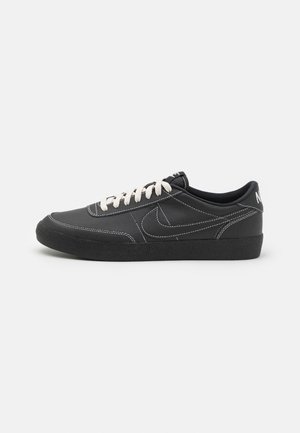 Sneakers neri in pelle con cuciture e lacci bianchi. Presentano un design liscio e una suola in gomma nera strutturata. Logo sul tallone.