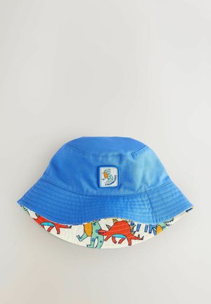 Blauer Bucket Hat mit einer strukturierten Stoffoberfläche und einem bunten Dinosaurier-Muster im Inneren. Verfügt über ein quadratisches Etikett mit einer Dinosaurier-Grafik.