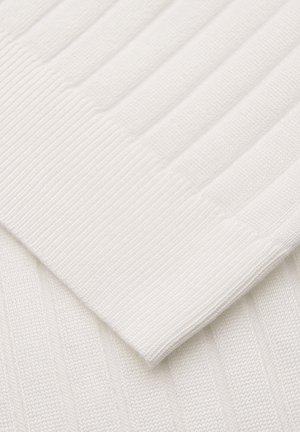 Close-up van wit geribd gebreid stof dat een gevouwen mouwboord toont met verticale en horizontale ribbelpatronen.