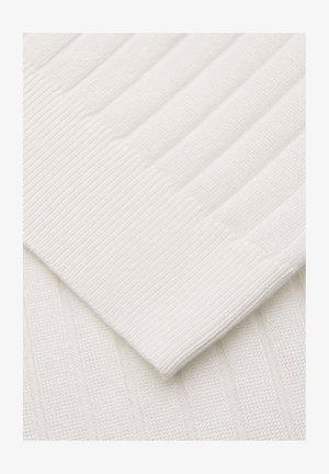 Zbliżenie na biały prążkowany dzianinowy materiał pokazujący złożony mankiet rękawa z pionowymi i poziomymi wzorami prążków.