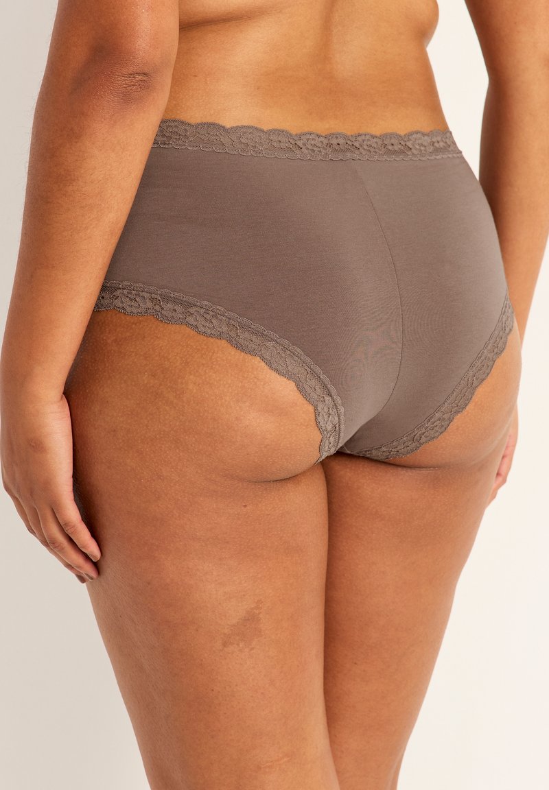 Bruna bomullsbriefs med spetsdetaljer vid midjan och benöppningarna. Slät textur med hög midja och minimal täckning.