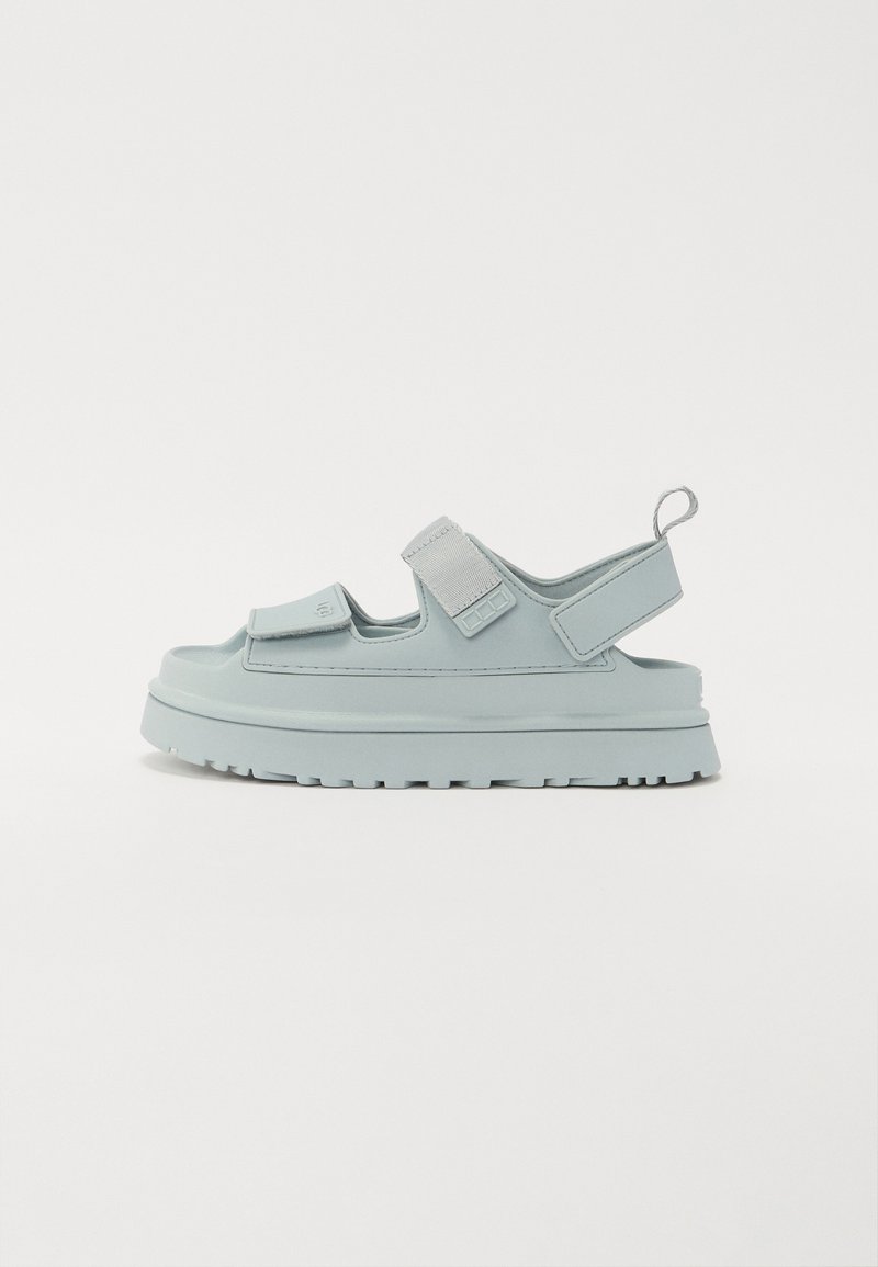 Light blue sandals with two adjustable Velcro straps, a thick sole, and a textured tread for grip. Lightweight material and open design.