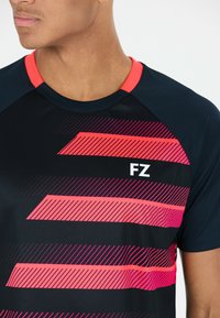 Svart träningströja med rund halsringning, prydd med djärva rosa ränder och bokstäverna "FZ" i vitt. Tillverkad av ett mjukt, andningsbart material.