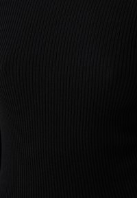 Zwarte ribgebreide stof met verticale lijnen en een gladde textuur. Ontworpen in een aansluitende snit voor een eigentijdse uitstraling.