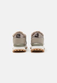 Sneakers with a soft, fur-trimmed heel, metallic gray leather upper, translucent sole, and textured rubber outsole for grip.