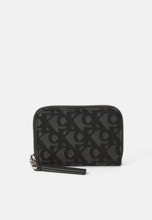 Portafoglio in tessuto nero con un design a logo sottile e decorato. Presenta una chiusura con zip e un tirante in pelle. Superficie texture.