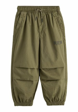 Olijfgroene casual broek met elastische tailleband, trekkoord, zakken, elastische boorden en zwarte tekst met "Limited Edition" in het Engels en Japans.