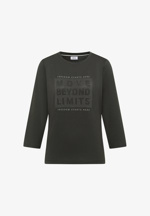 Chemise verte foncée à manches longues avec un col arrondi et un motif imprimé comportant le texte "DÉPASSEZ LES LIMITES" en accents clairs.