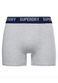 Grijze katoenen boxershorts met een vlakke marineblauwe tailleband met het 'SUPERDRY' logo in het wit. Gladde textuur, aansluitend ontwerp en een gemiddelde taillehoogte.