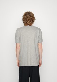 Grå bomulds t-shirt med korte ærmer, rund halsudskæring og en afslappet pasform. Glat tekstur, ingen synlige mønstre eller detaljer.