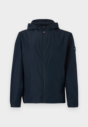 Tumesinine kerge jakk, millel on kapuuts, eesmine lukk, kaks küljetaskut, elastsed varrukasuu ja varrukal logoplaat.