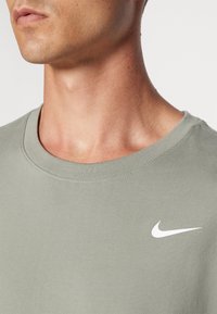 Nike Performance CREW SOLID - Sports T-shirts - dark stucco