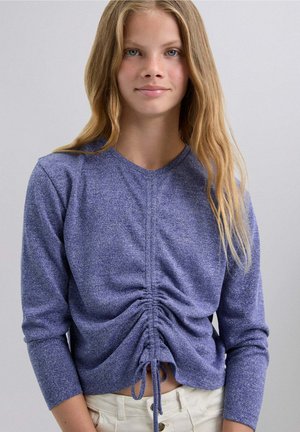 Top de manga larga morado con detalle de fruncido en la parte frontal y cordón ajustable. Textura suave, diseño ajustado y ligero brillo en toda su superficie.