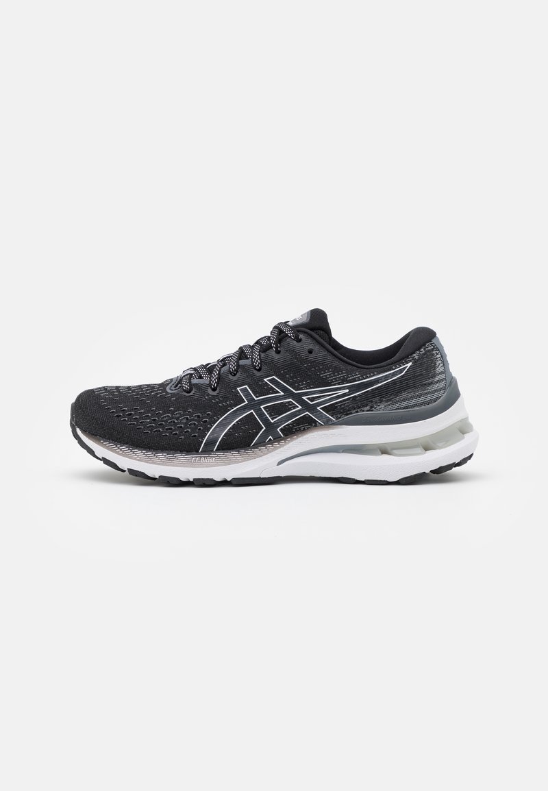 Chaussure de running noire et blanche avec tige en mesh, lacets à motifs, semelle rembourrée et logo distinctif de la marque sur le côté.