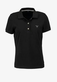 Polo negro de manga corta con dos botones blancos y pequeño logo blanco de GANT en el lado izquierdo del pecho.