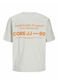 Cream-colored t-shirt with short sleeves and a crew neck. Features orange text on the back with branding and design details.
