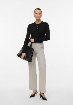 Sort ribbet skjorte med lange ærmer, krave og knapper, lys grå lige ben bukser, sort læder håndtaske og sorte spidse hæle.