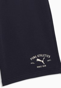 Shorts de sport bleu marine en tissu doux avec un logo blanc brodé portant les textes "PUMA ATHLETICS" et "SINCE 1948".