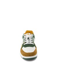 Scarpa con tomaia in cuoio bianco, dettagli in suede verde e punta marrone. La foderatura gialla in tessuto e i lacci bianchi completano il design.