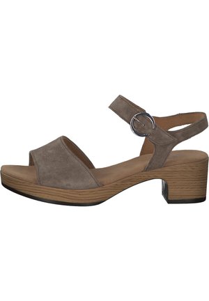 Zamszowe sandały w odcieniu taupe z szerokim paskiem na palce, paskiem na kostkę z okrągłą metalową klamrą i blokowym obcasem o wzorze słojów drewna.