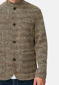 Braune und beige Strickjacke mit Stehkragen, vorderem Knopfverschluss, zwei aufgesetzten Taschen und strukturiertem Stoff.