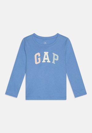 Chemise à manches longues bleue en tissu doux, avec un col arrondi et un logo "GAP" dans des couleurs pastel sur la poitrine.