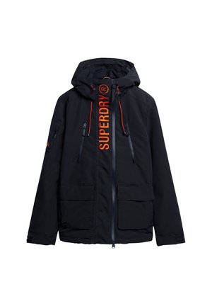 Veste noire à capuche avec fermeture éclair à l'avant, deux grandes poches basses, poches poitrine zippées et texte orange "SUPERDRY" le long de la ligne de la fermeture éclair.