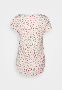 Top a maniche corte con motivo floreale, caratterizzato da uno sfondo crema con accenti rosa e neri, colletto rotondo e orlo leggermente curvato.