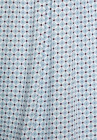 Tela azul clara con un patrón geométrico repetido de diamantes blancos y pequeños puntos rojos. Textura suave con un ligero brillo.